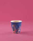Blue cup with floral pattern on a pink background