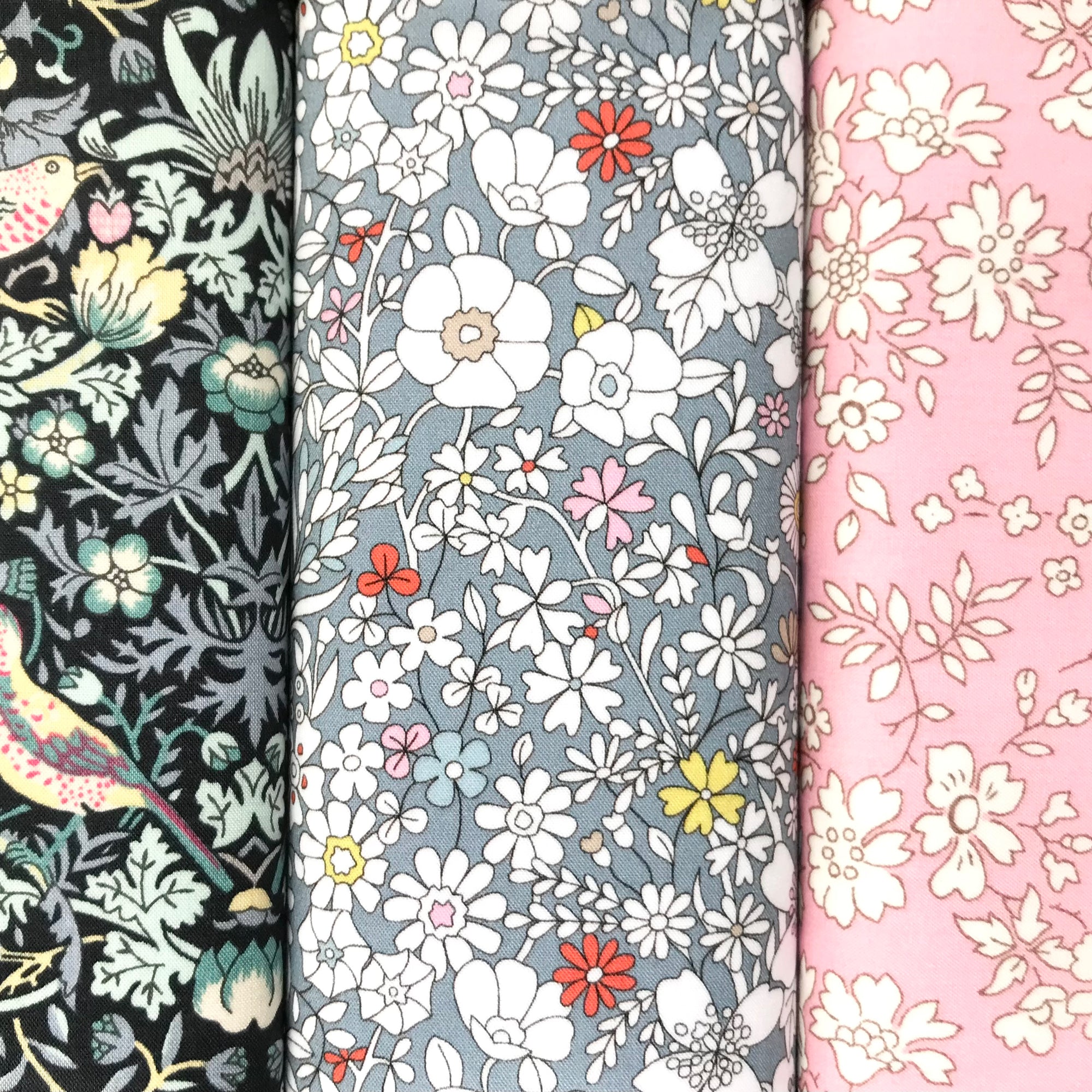 Three floral fabric hankies in black, grey and pink.