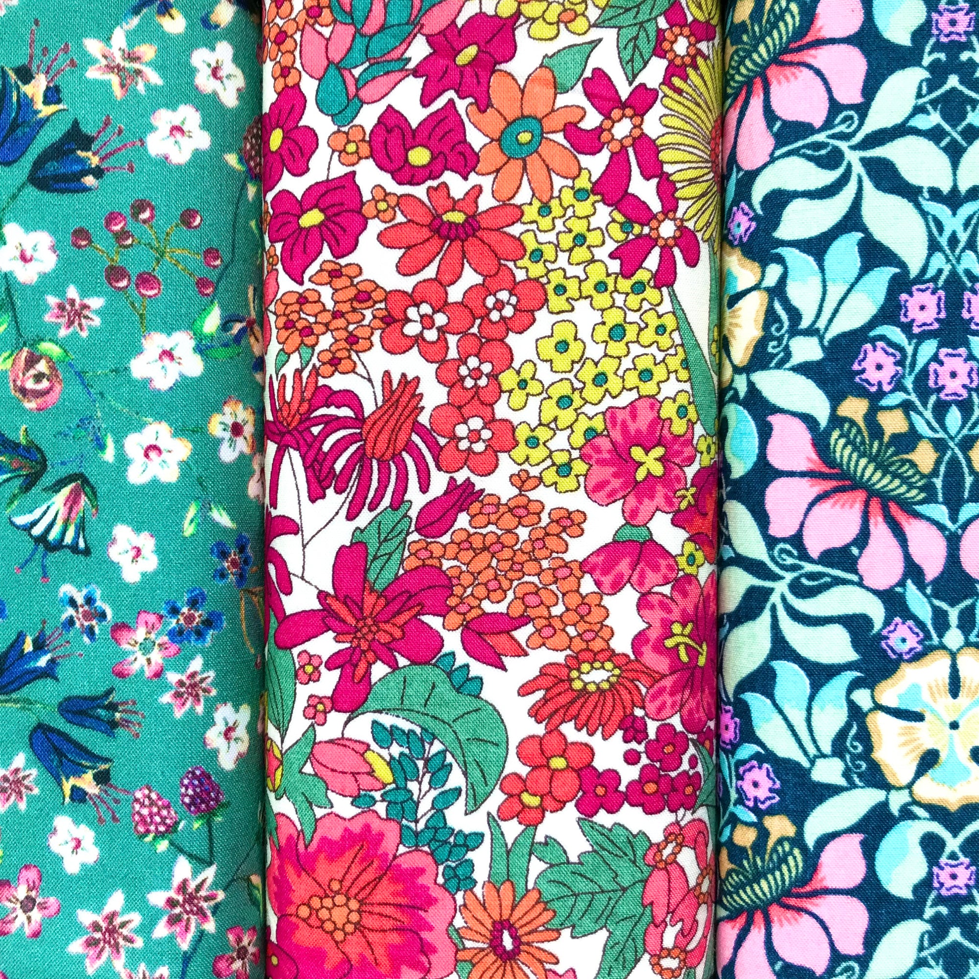 Three colourful floral fabric hankies arranged side by side.