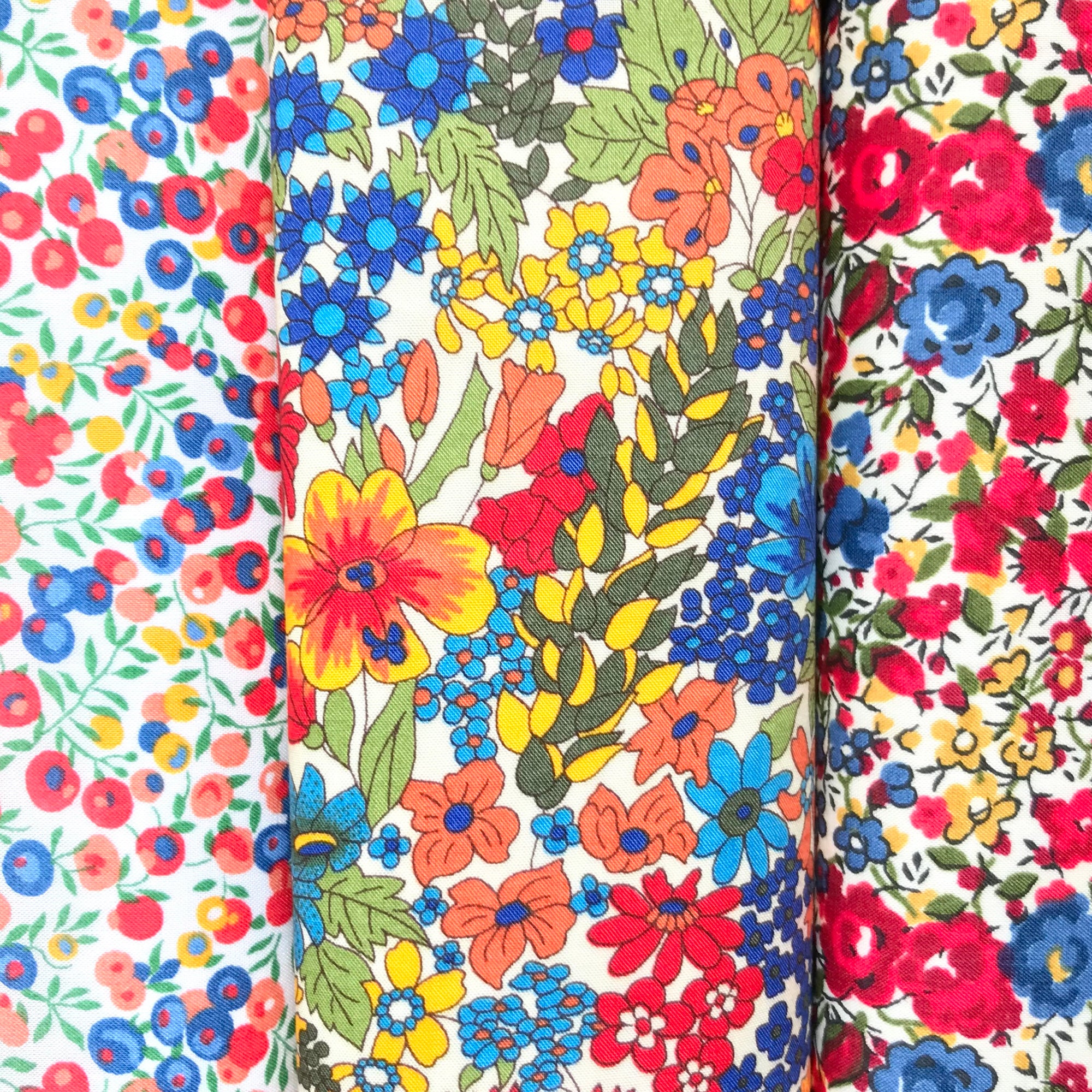 Three cotton hankies in red, blue and yellow Liberty prints.