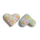 Two heart-shaped lavender bags with floral patterns on a white background