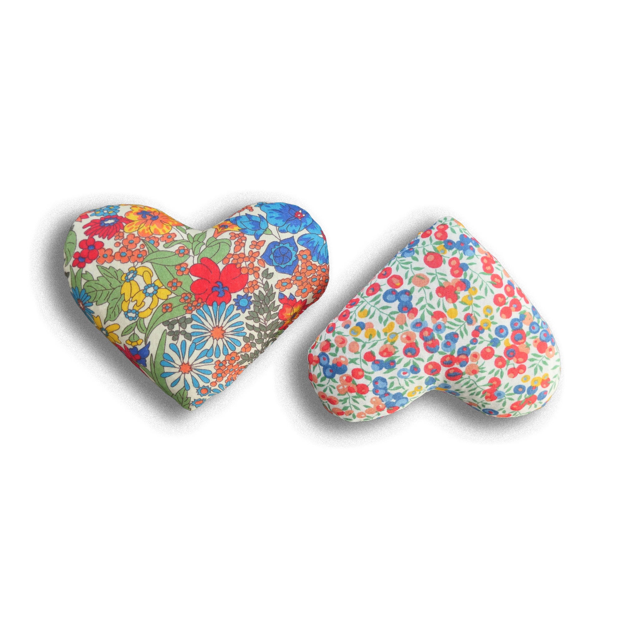 Two heart-shaped sachets with red, yellow and blue floral patterns on a white background