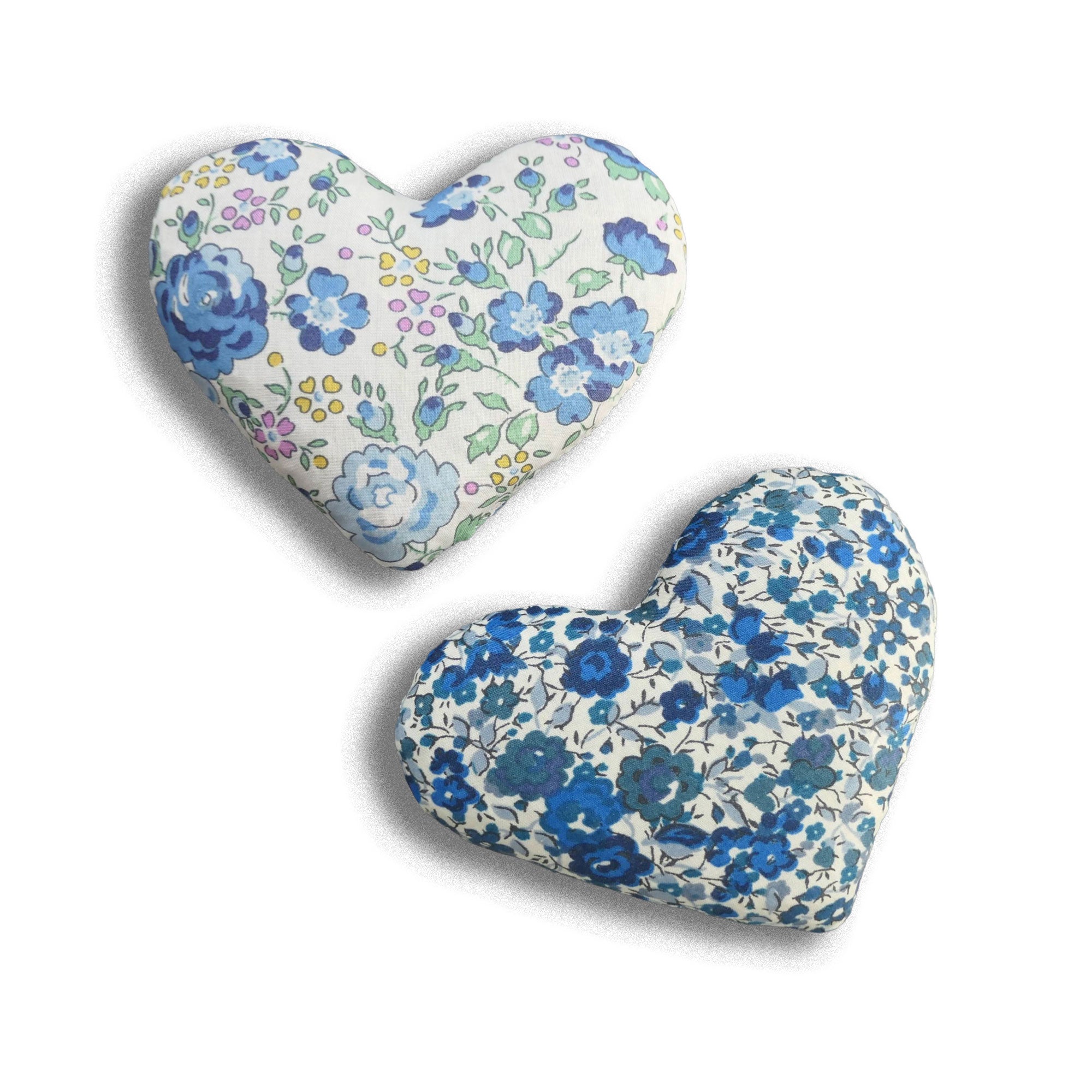 Two heart-shaped cushions with floral patterns on a white background