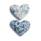 Two lavender hearts with floral patterns in Liberty fabric on a white background