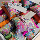 Colourful fabric bags with floral patterns on a textured surface