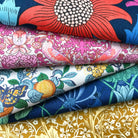 Stack of colourful floral and nature-themed fabrics
