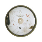 Round glass with decorative lid featuring illustrations and text on a white background