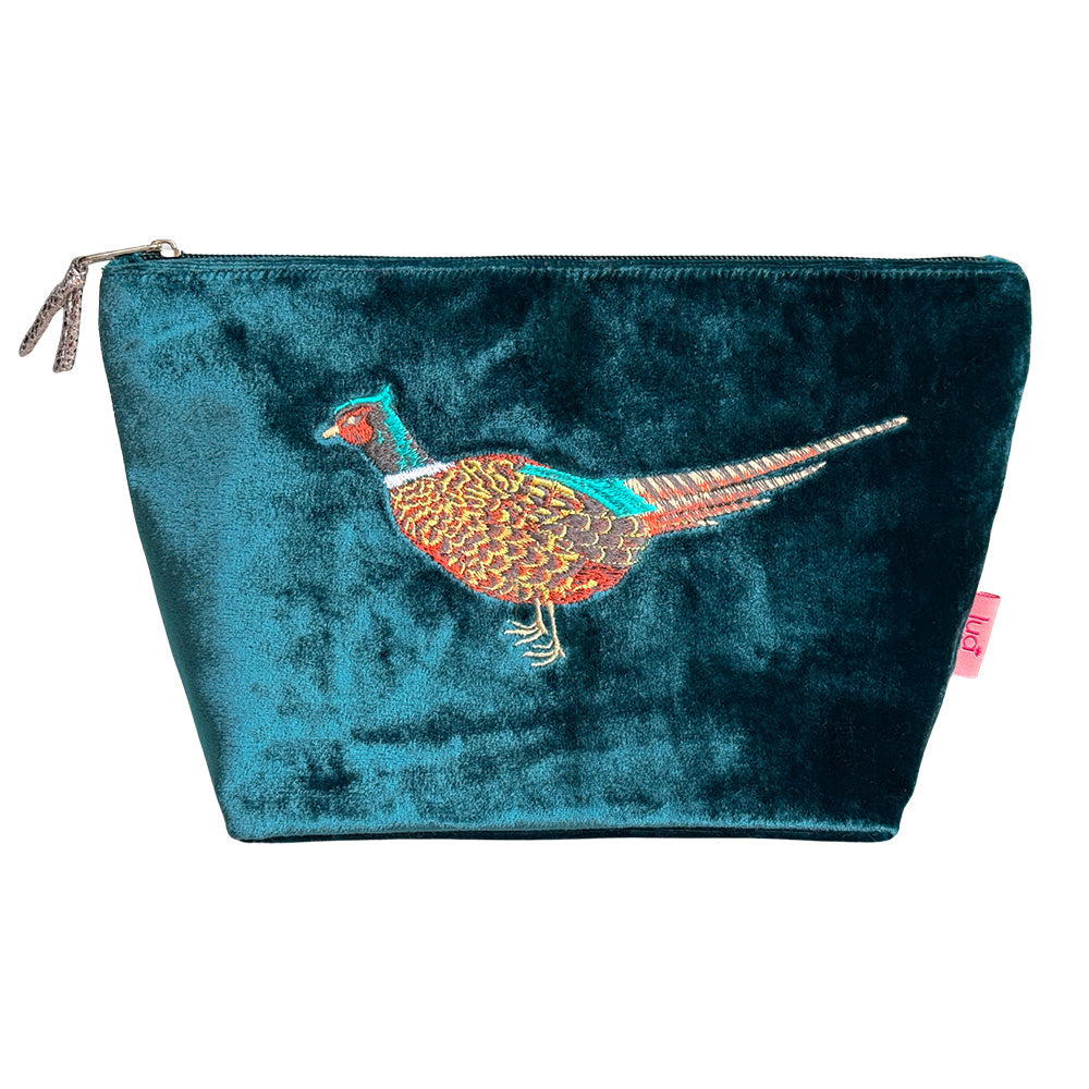 A teal velvet cosmetic pouch featuring an embroidered pheasant bird on the front, with a silver zipper closure and a small pink tag on the side.