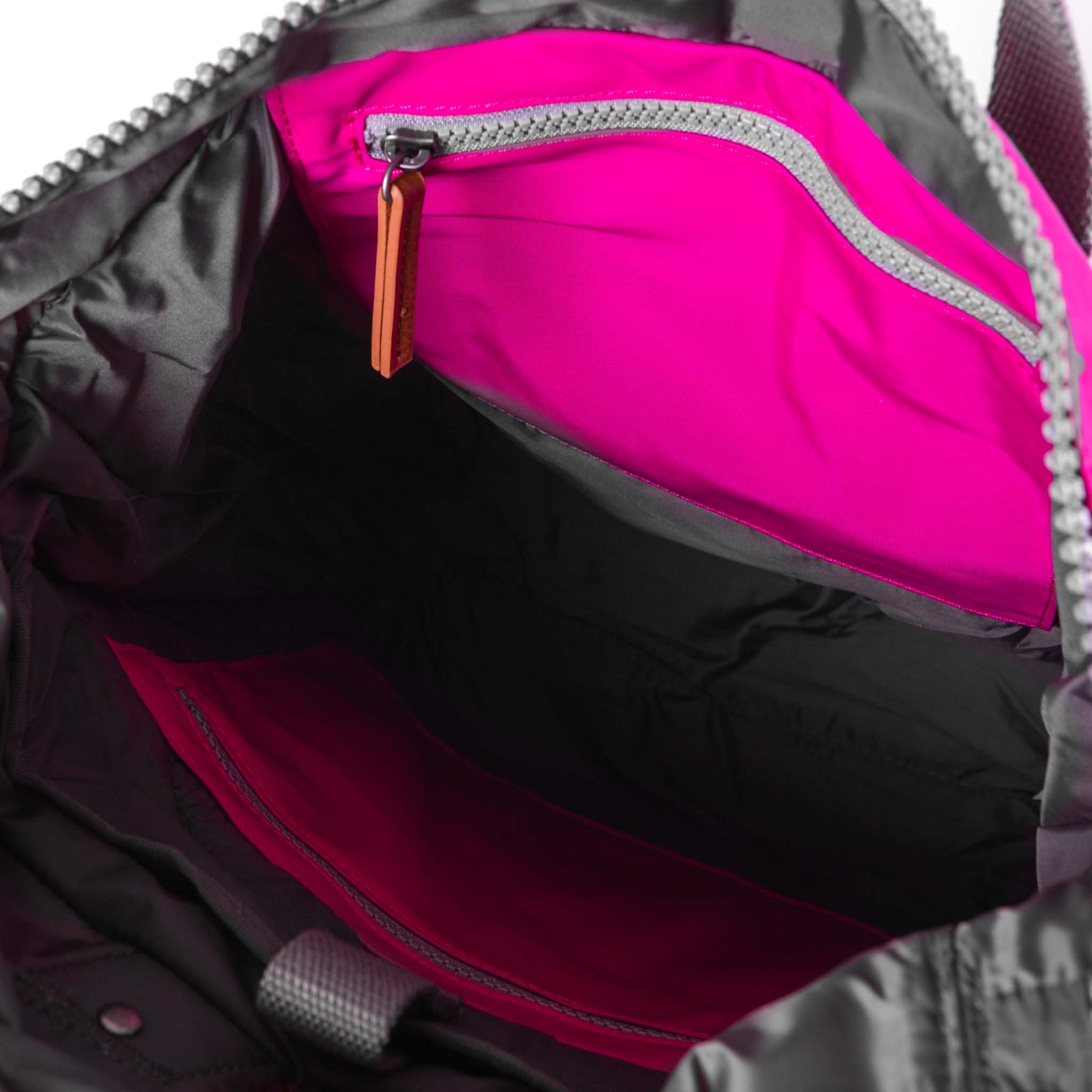 Close-up of a pink zipper on a backpack with a gray background