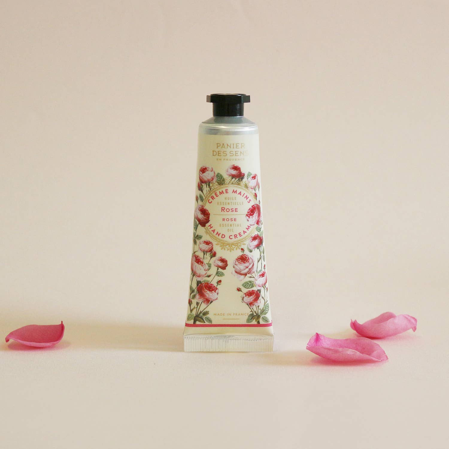 Hand cream bottle with floral design on a beige background