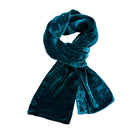 A dark teal velvet scarf, styled in a loop with one end hanging down, shown against a plain white background.