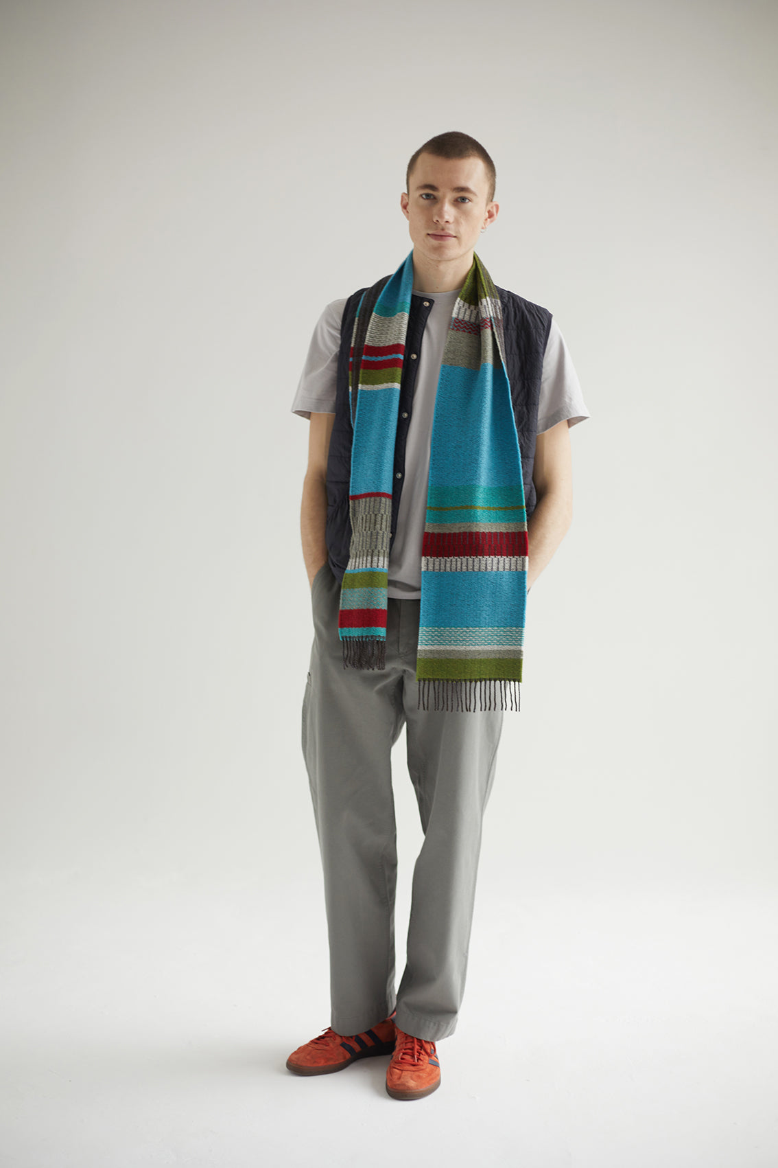Person wearing a colorful scarf with a neutral background