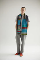 Person wearing a colorful scarf with a neutral background