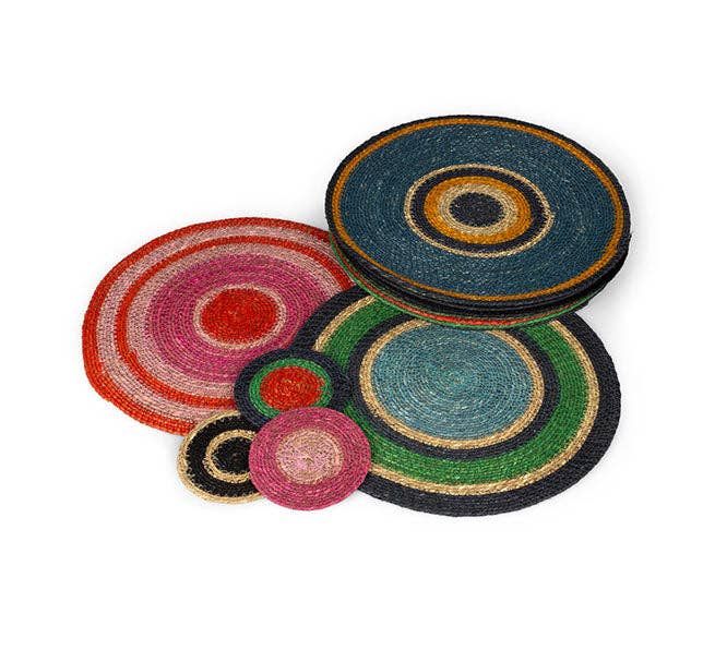 A set of round braided woven placemats with concentric circular patterns in various colors including blue, green, pink, red, orange, and black, arranged on a plain white background.