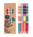 Set of colourful striped candles with a cardboard box featuring a lion design.