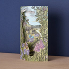 Decorative 3d card with nature-themed cover featuring animals and plants sat on a wooden surface against a blue background