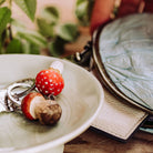 Keychain with mushroom design on a white dish, blurred background
