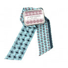 Scarf with floral pattern and tin labeled 'Les Belles Vacances' on a white background