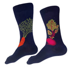 A pair of navy blue crew socks with  vegetable designs. One sock features an orange carrot with green leafy stems, and the other features a pinkish-red beet with green and yellow leaves.