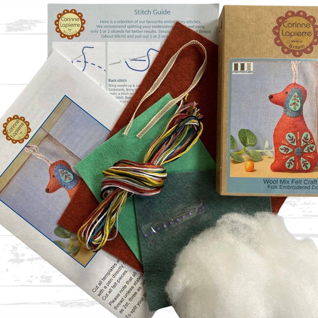 Craft kit with felt pieces, embroidery floss, and a box of Corinne Lapierre products on a white background.