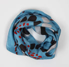Blue scarf with black and red abstract pattern on a white background