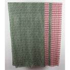 A rectangular fabric panel or curtain hanging flat against a plain light background, featuring a sage green field with a repeating circular spiral pattern and a vertical red border with a repeating geometric circle motif.