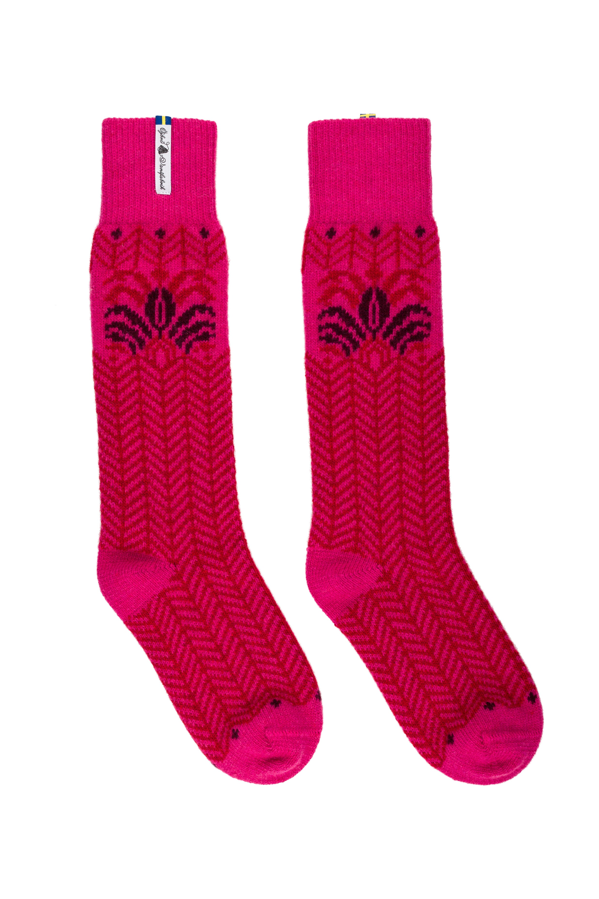 A pair of bright pink crew socks with a dark pink herringbone knit pattern and a small white brand tag near the cuff, displayed against a plain white background.