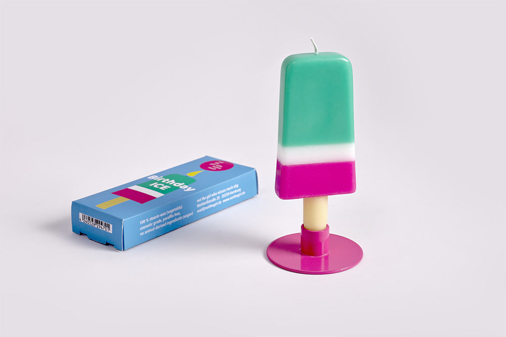 Colorful popsicle-shaped candle with a box on a light gray background