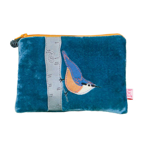 Photo of a small rectangular purse made from blue velvet with a blue and orange bird sitting on a grey branch appliquéd onto the front. The zip is orange and has a blue beaded spherical zip pull.